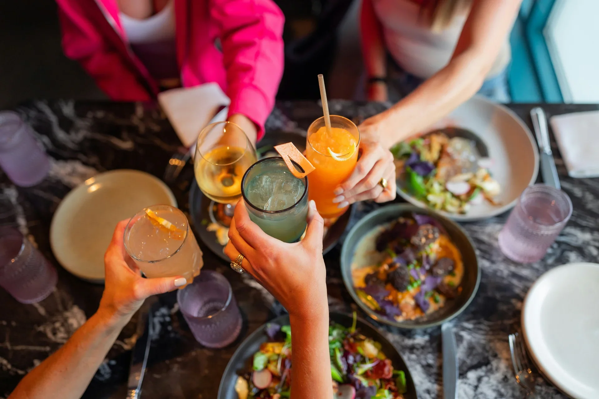 Friends sharing food and raising glasses in a cheers